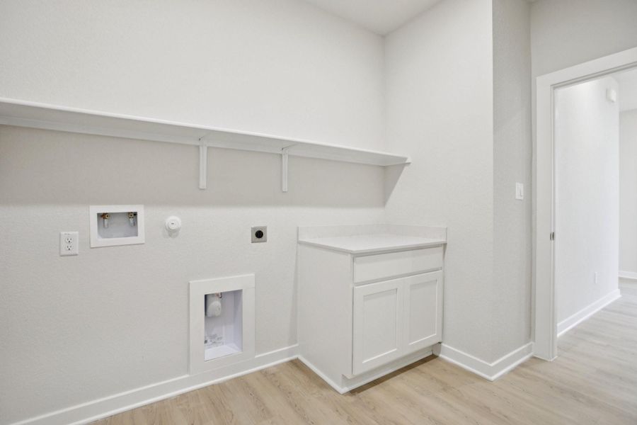 Laundry area featuring light wood finished floors, hookup for a gas dryer, electric dryer hookup, and hookup for a washing machine