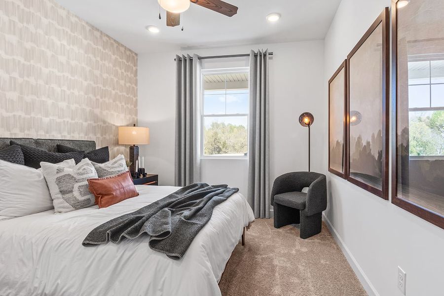 A bedroom with a bed and a chair.