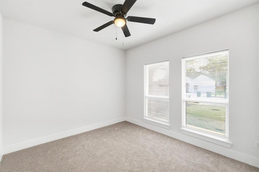 Unfurnished room featuring light carpet and ceiling fan