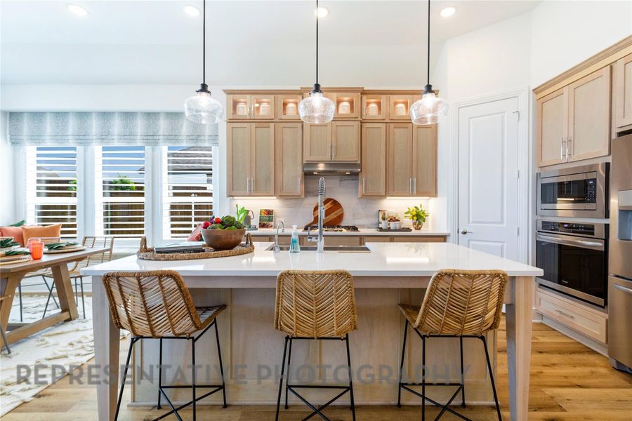 Kitchen featuring light brown cabinetry, light wood-type flooring, pendant lighting, appliances with stainless steel finishes, and recessed lighting Kitchen featuring light brown cabinetry, light wood-type flooring, pendant lighting, appliances with stainless steel finishes, and recessed lighting