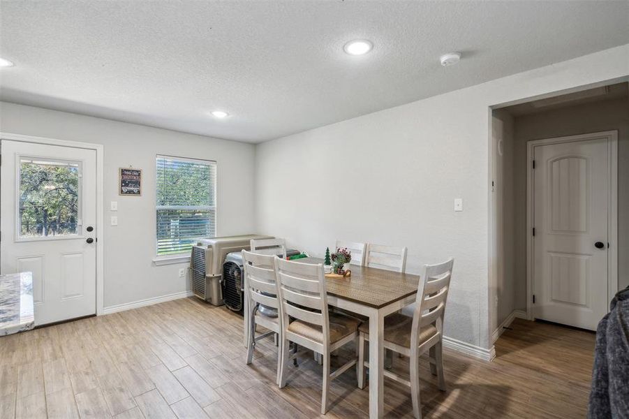 Dining area with light hardwood / wood-style flooring and a textured ceiling