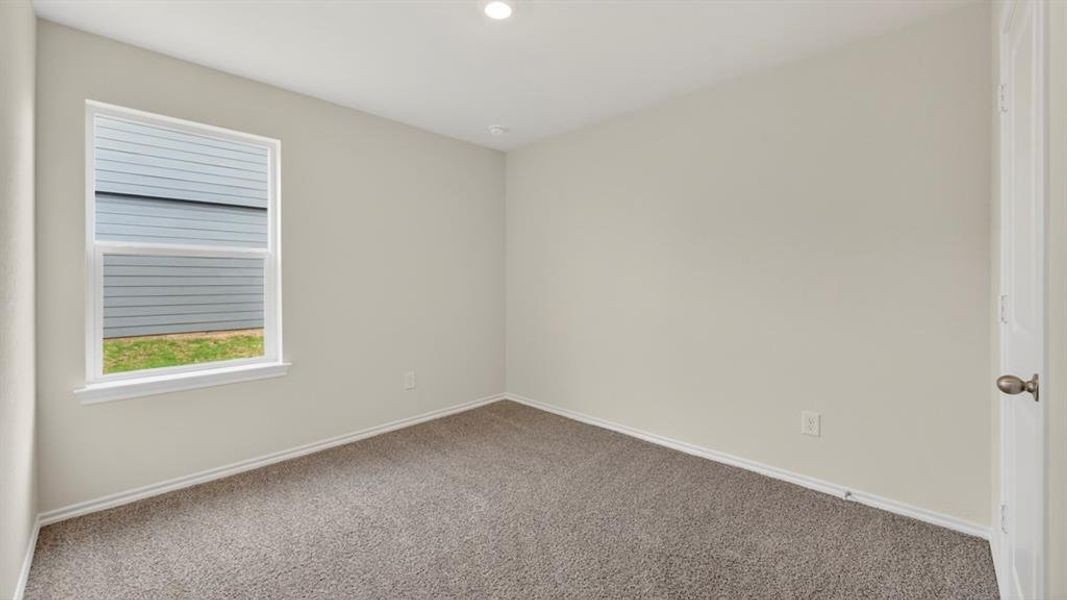 Carpeted room with a single window, recessed lighting, and a white interior door