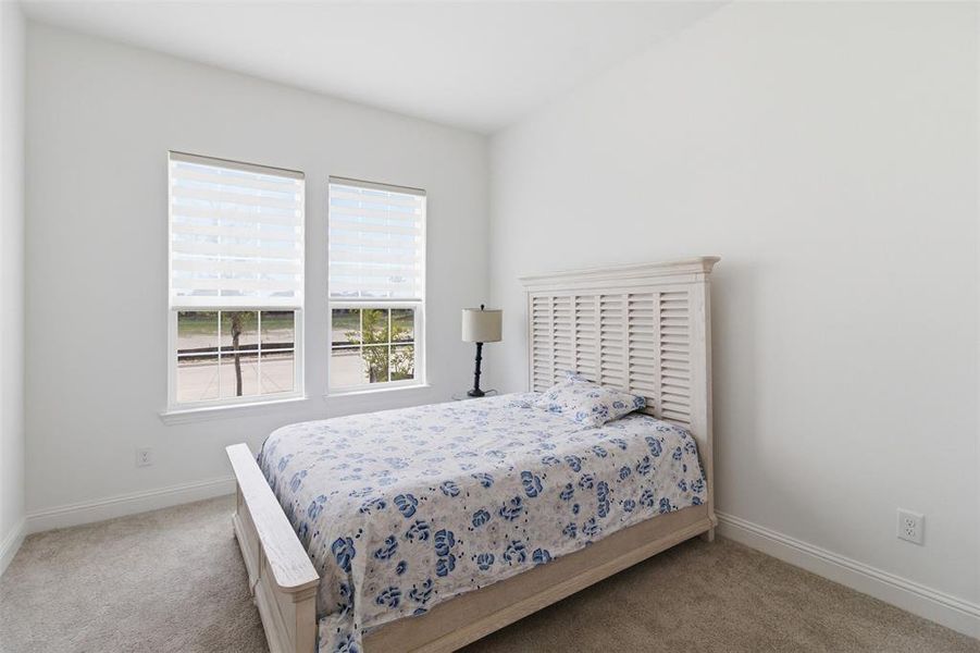 Room featuring two windows with horizontal blinds, light-colored walls, and carpet flooring