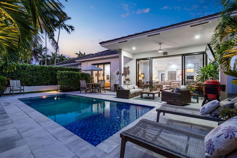 Backyard pool area with covered patio.