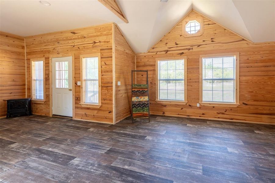 Spacious room with wood-finish flooring and extensive natural wood paneling