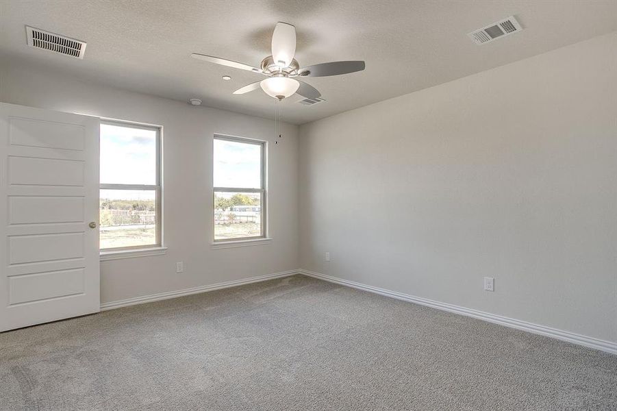 Empty room with light carpet and ceiling fan