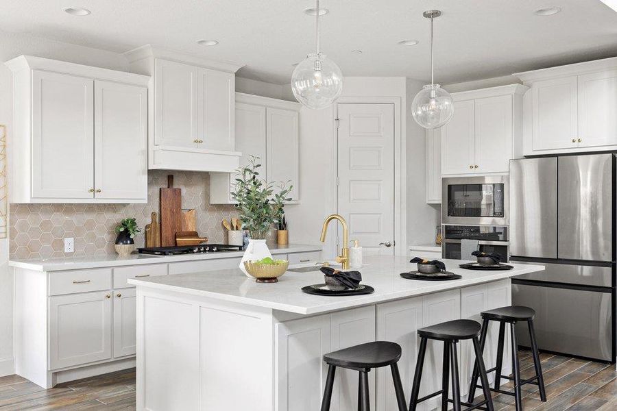 A pristine culinary space features an inviting kitchen island and state-of-the-art stainless steel appliances.