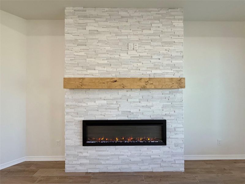 Detailed view of wood finished floors and a stone fireplace