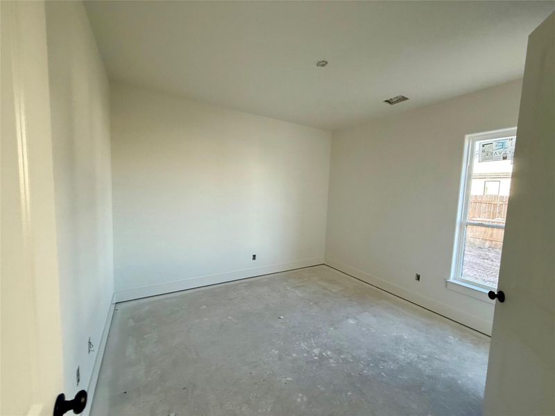 Empty room with unfinished concrete flooring and baseboards Empty room with unfinished concrete flooring and baseboards