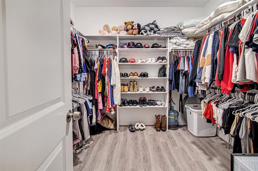 Spacious closet with light hardwood / wood-style floors