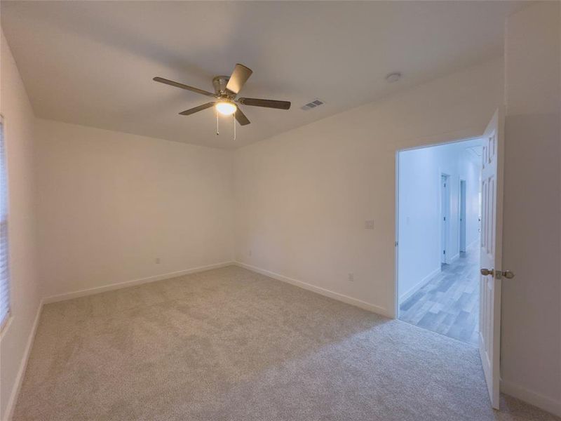 Carpeted spare room with ceiling fan