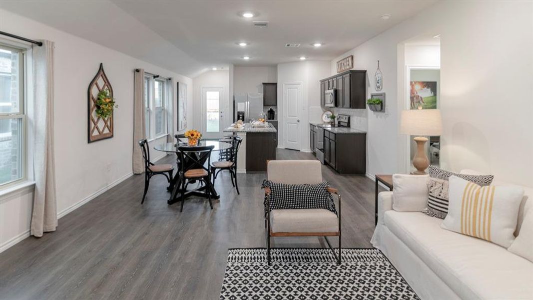 Open-concept living area with wood-finish flooring, recessed lighting, and white walls Open-concept living area with wood-finish flooring, recessed lighting, and white walls