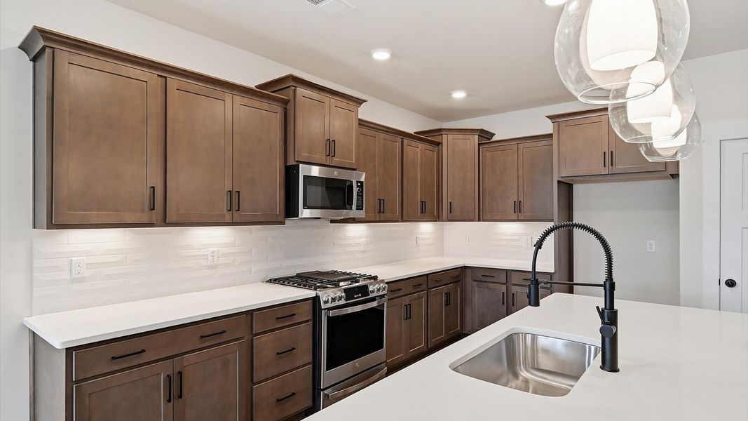 Elegant kitchen featuring a 9-foot island with pendant lighting and tasteful finishes throughout in Moore, SC