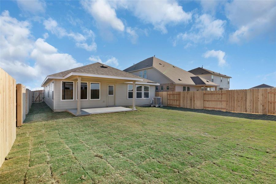 Back of property featuring a fenced backyard, a patio, and a shingled roof