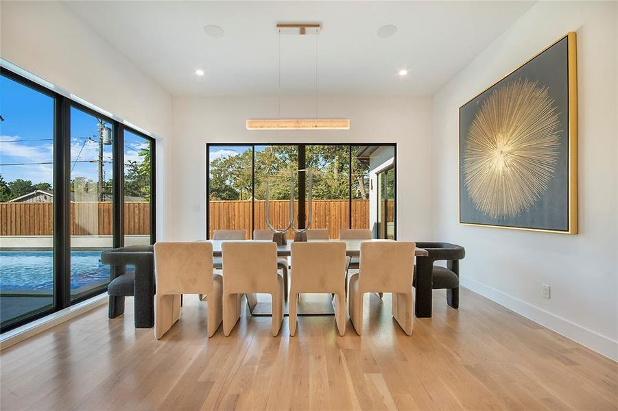 Dining room with light wood-style floors and recessed lighting