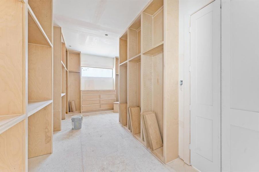 Custom oak 24 in built-in shelving and a quartz countertop enhance the oversized primary closet.