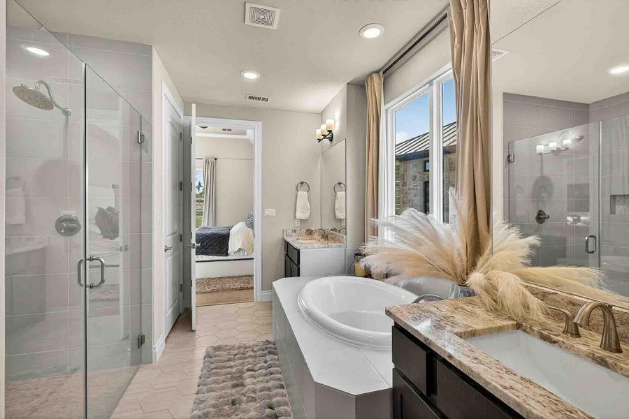 Ensuite bathroom featuring a stall shower, two vanities, a garden tub, light tile patterned flooring, and recessed lighting