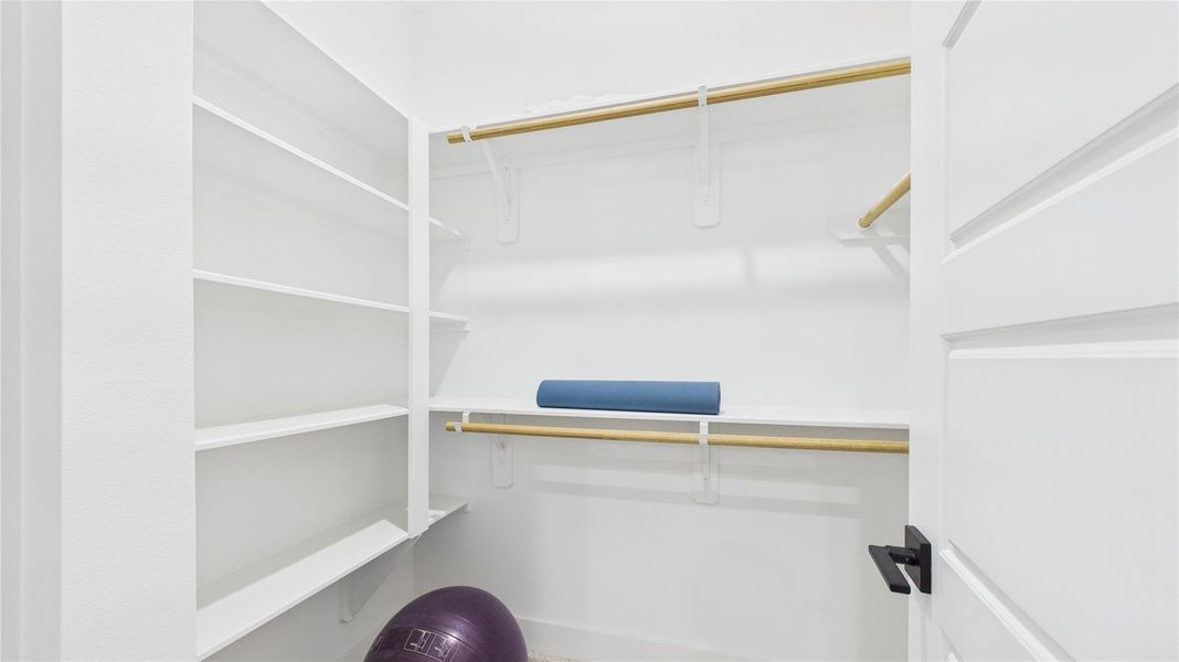 This spacious walk-in primary closet offers ample storage and organization, designed for both functionality and style. With generous shelving, hanging space, and well-placed lighting, it creates an elegant and practical wardrobe area. Thoughtfully designed to maximize convenience, this closet enhances the home's luxury and everyday comfort. This spacious walk-in primary closet offers ample storage and organization, designed for both functionality and style. With generous shelving, hanging space, and well-placed lighting, it creates an elegant and practical wardrobe area. Thoughtfully designed to maximize convenience, this closet enhances the home's luxury and everyday comfort.