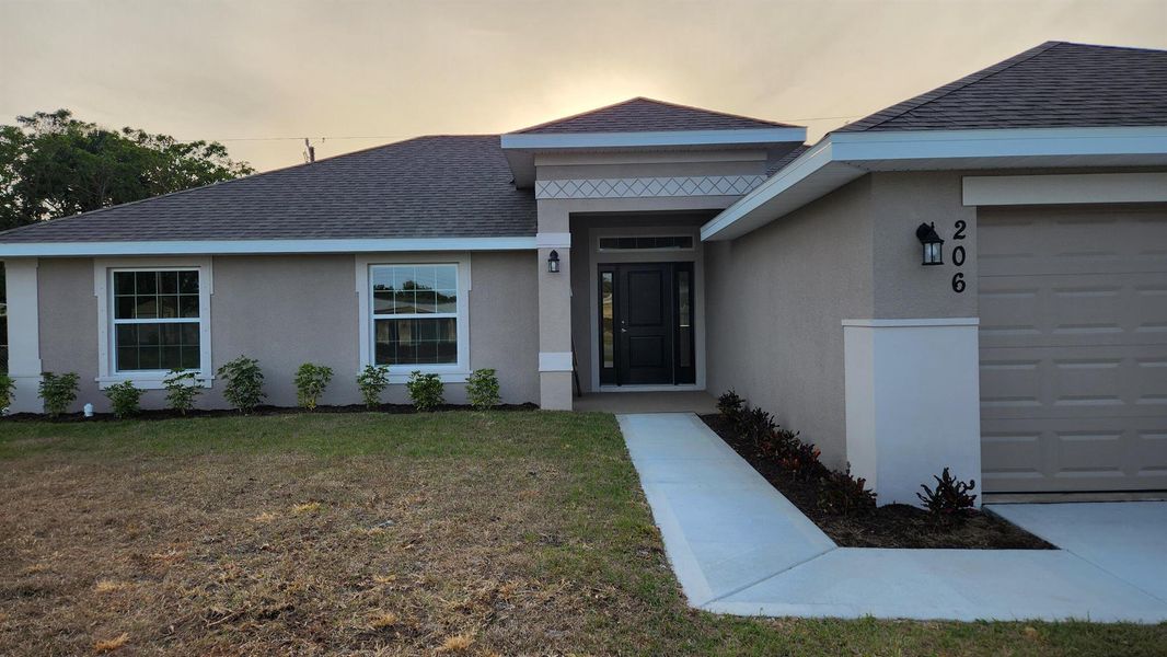 Front exterior of a new home in Gatlin, Port St. Lucie, FL, highlighting curb appeal (Image 13).