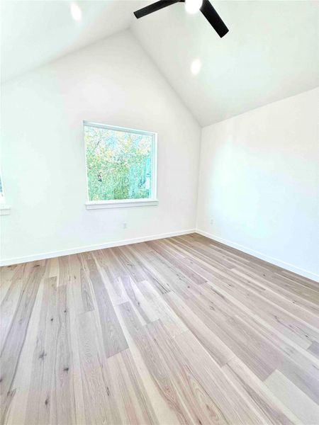 Unfurnished room with light wood-style flooring, high vaulted ceiling, ceiling fan, and recessed lighting