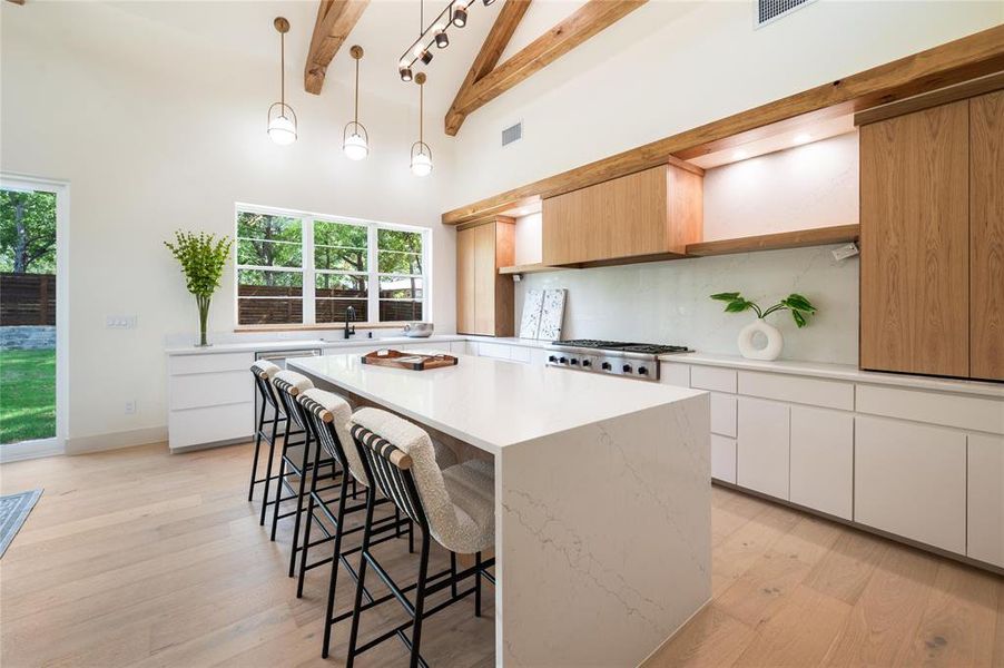 Kitchen with light hardwood / wood-style floors, a center island, and white cabinets