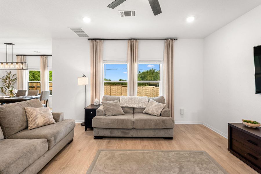 Bright, open concept living and dining areas flow seamlessly together, showcasing beautiful hardwood flooring throughout. Bright, open concept living and dining areas flow seamlessly together, showcasing beautiful hardwood flooring throughout.
