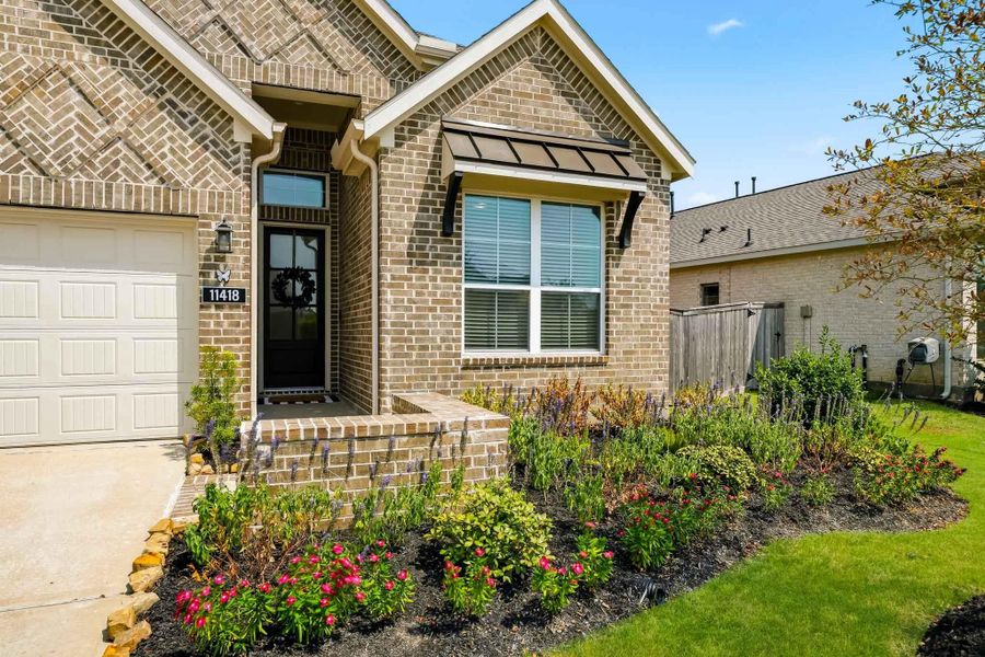 This all-brick home showcases distinctive architectural character with an eye-catching chevron brick accent, timeless masonry craftsmanship, and a beautifully landscaped front yard that enhances its classic curb appeal.