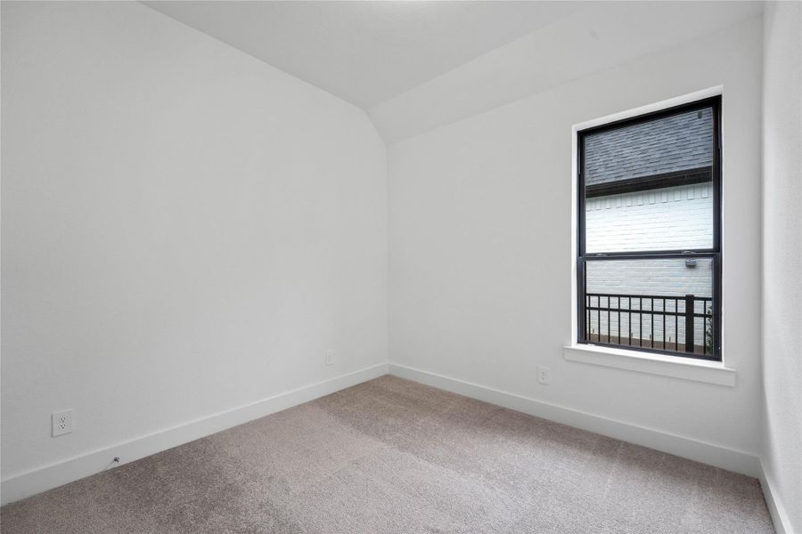 Another secondary bedroom featuring plush carpet, neutral tone wall color, large window, and an ample sized closet.