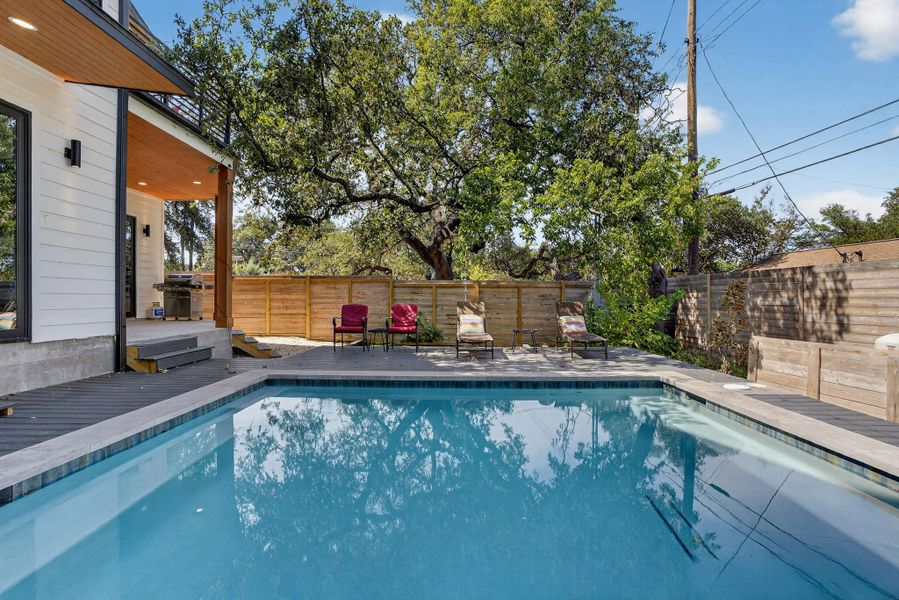 View of pool featuring a patio, a fenced backyard, and area for grilling