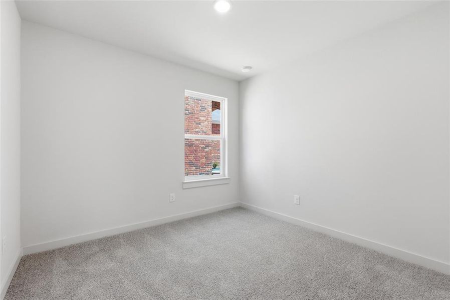 Unfurnished room featuring light carpet and baseboards