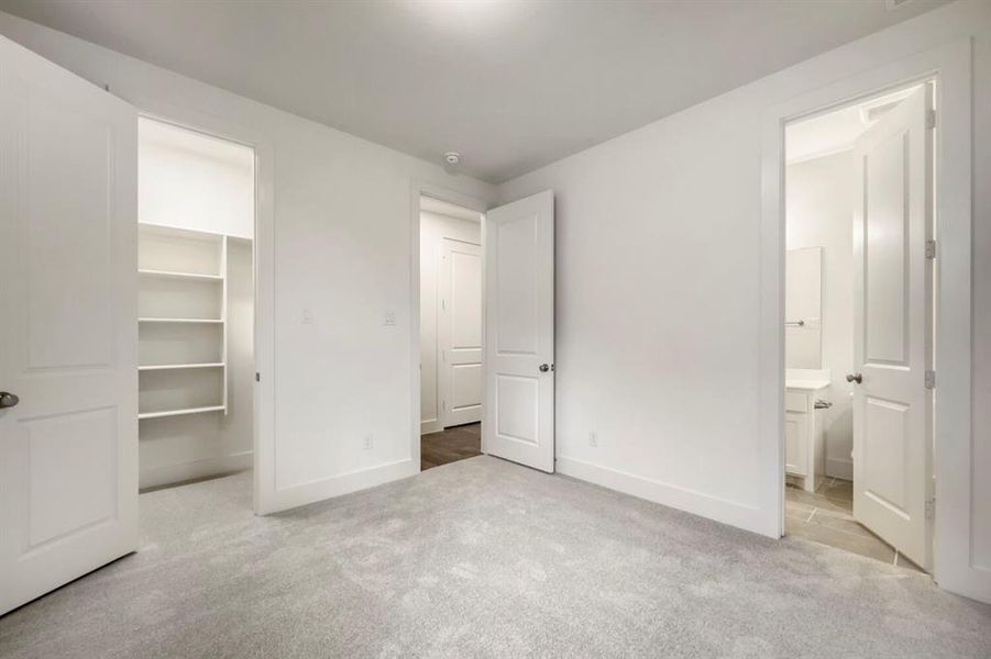 Spacious room featuring light gray carpet flooring, white walls, and bright overhead lighting Spacious room featuring light gray carpet flooring, white walls, and bright overhead lighting