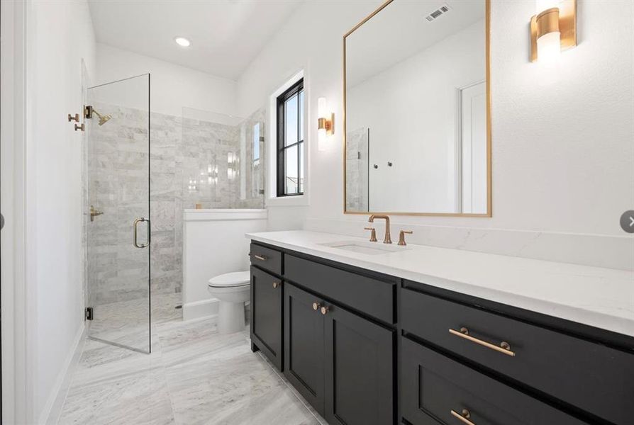 Bathroom featuring toilet, a shower with door, and vanity