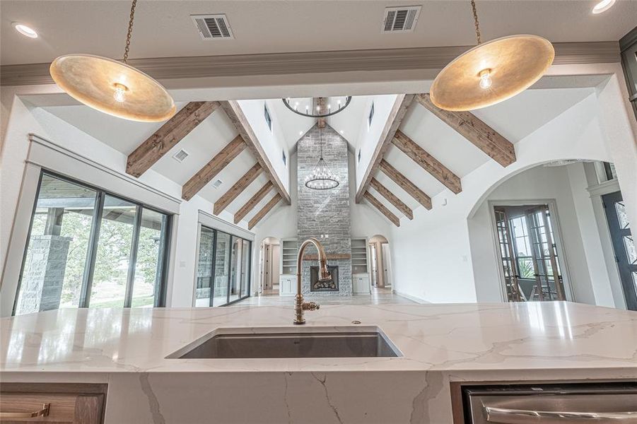Kitchen featuring light stone countertops, a chandelier, recessed lighting, decorative light fixtures, and open floor plan Kitchen featuring light stone countertops, a chandelier, recessed lighting, decorative light fixtures, and open floor plan