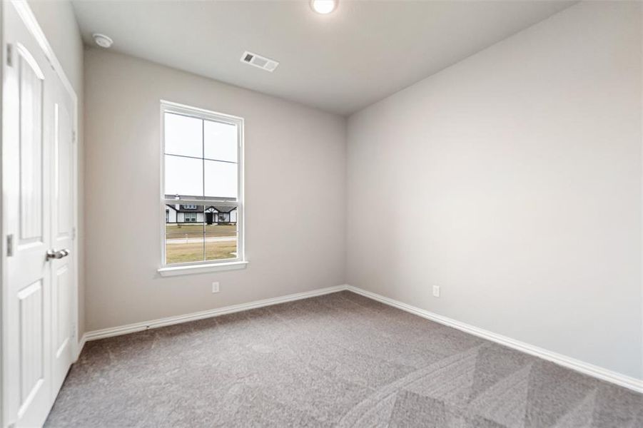 Spare room with light colored carpet and baseboards