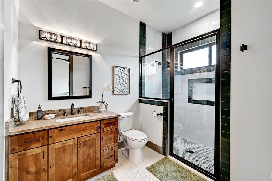 Full bathroom featuring vanity, a shower stall, and light tile patterned flooring