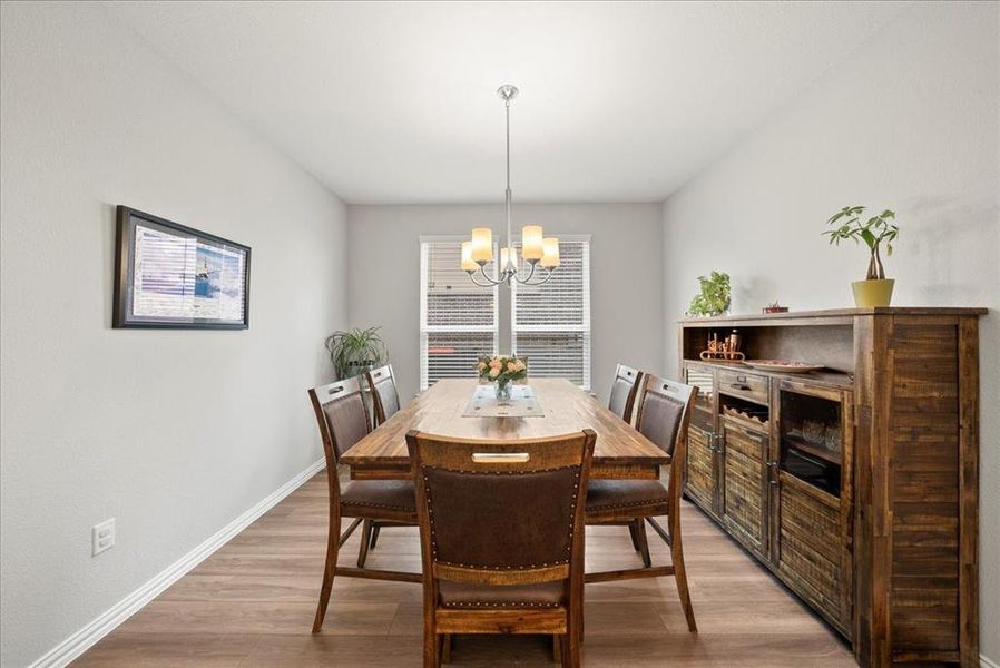 Dining area featuring an inviting chandelier and luxury vinyl flooring.