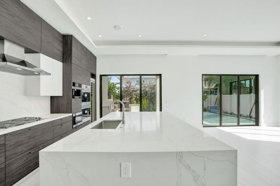 Oversized Island Seating 8+ with Seamless Indoor–Outdoor Alignment.