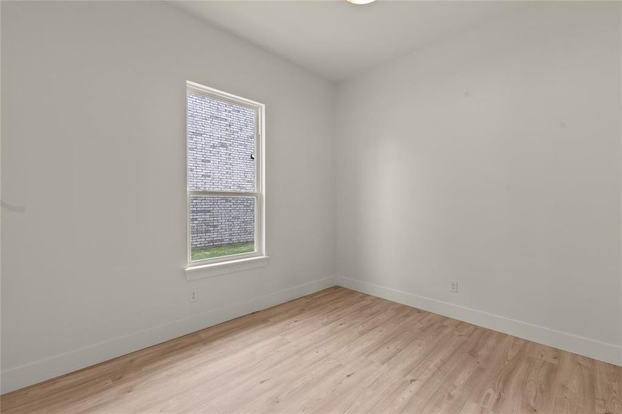 Empty room with baseboards and light wood finished floors Empty room with baseboards and light wood finished floors