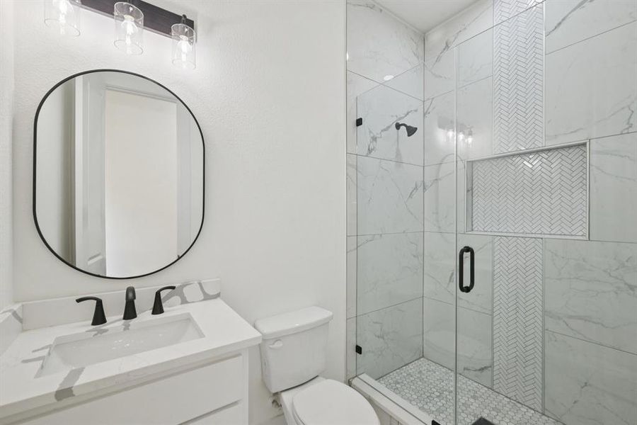 Bathroom featuring a shower stall and vanity