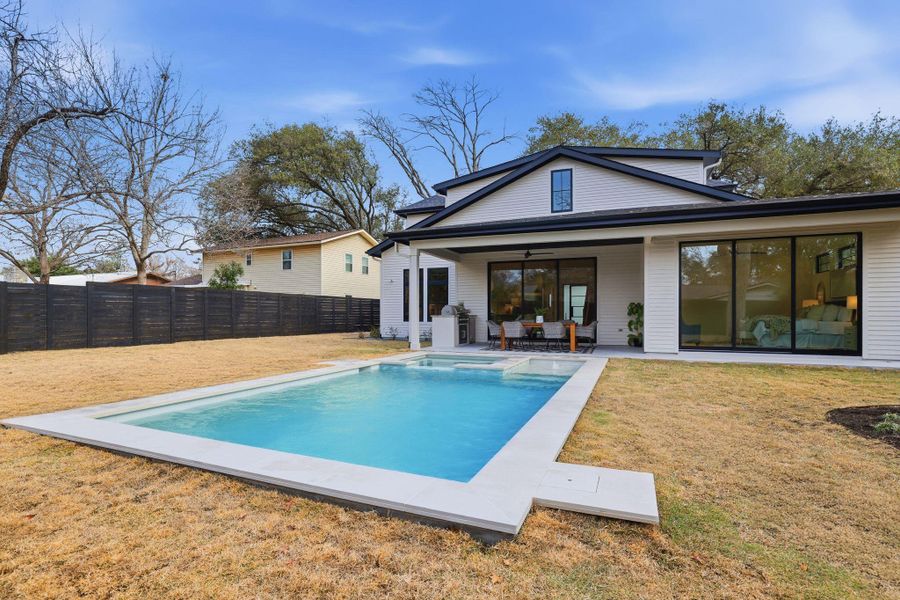 Back of property with a patio area, a fenced backyard, a pool with connected hot tub, and ceiling fan