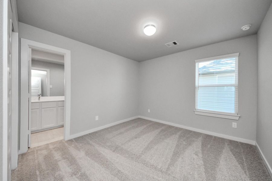 Secondary bedroom features plush carpeting, large windows that let in plenty of natural light, bright paint, and spacious closets. Sample photo of completed home with similar floor plan. Actual colors and selections may vary.