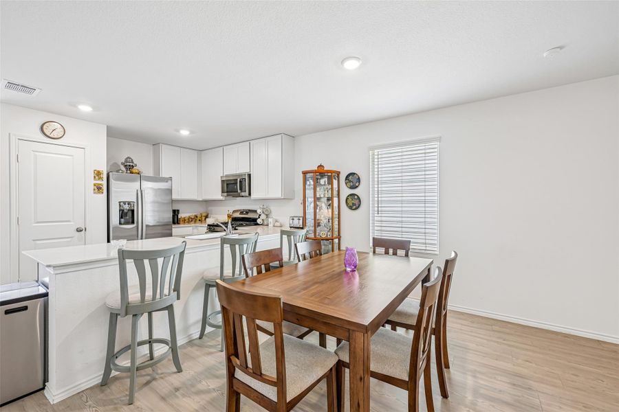 Open-concept kitchen and dining area featuring light wood-finish flooring Open-concept kitchen and dining area featuring light wood-finish flooring