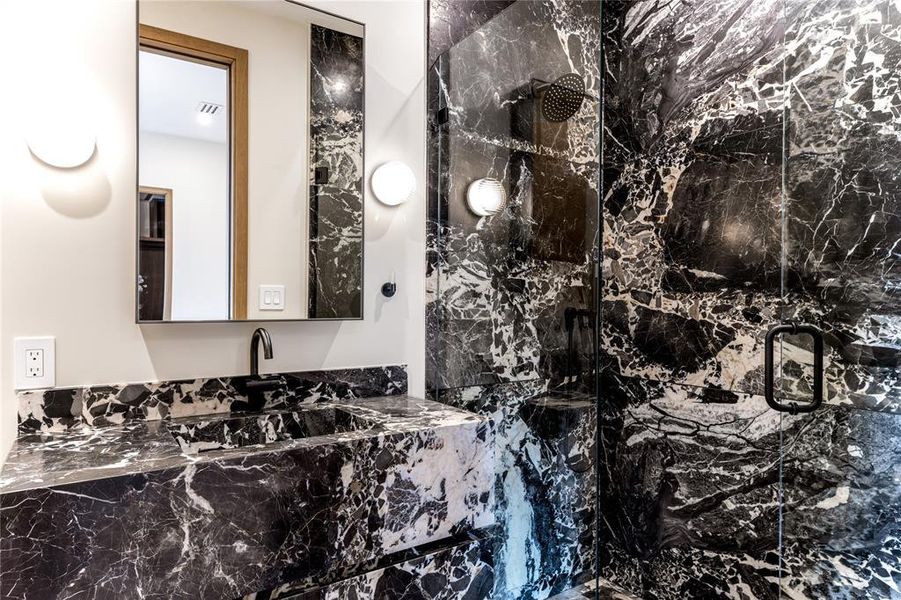 Bathroom with vanity and custom natural stone vanity and shower.