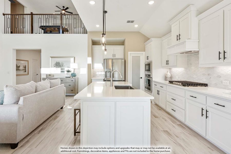 Open-concept kitchen with white cabinets, large island, and stainless appliances, open to living area with second-floor loft above. Open-concept kitchen with white cabinets, large island, and stainless appliances, open to living area with second-floor loft above.