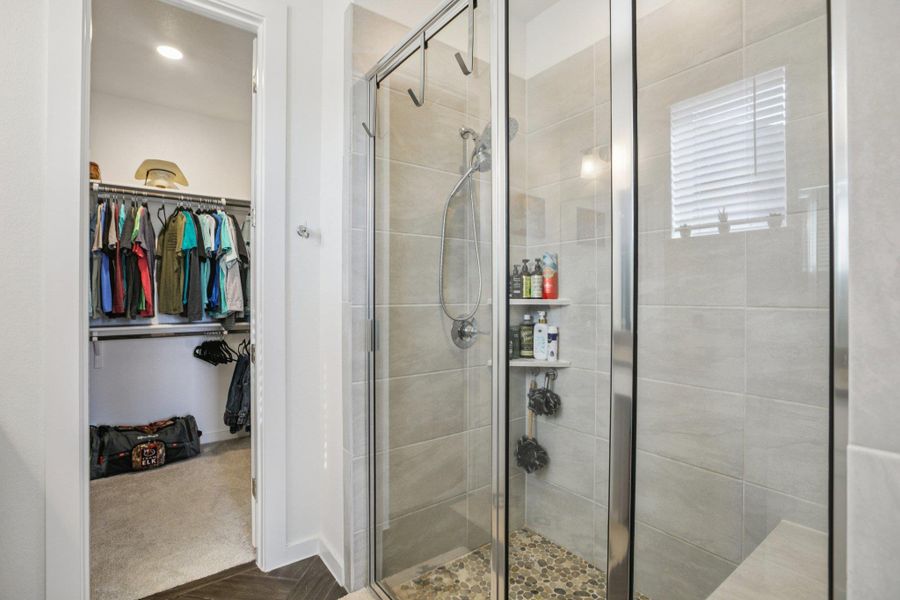 Bathroom featuring a walk in closet and a shower stall Bathroom featuring a walk in closet and a shower stall