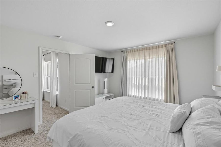 Bedroom featuring light carpet