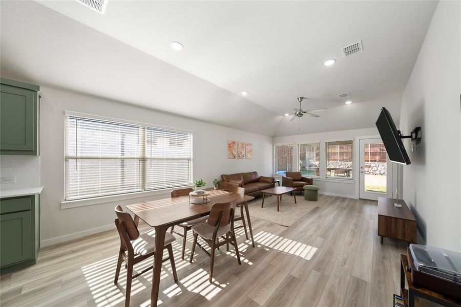 Dining space featuring light wood-type flooring, vaulted ceiling, and ceiling fan