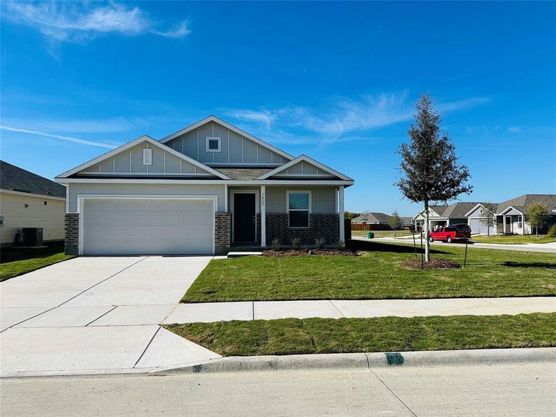 View of front facade with a front yard, central AC, and a garage