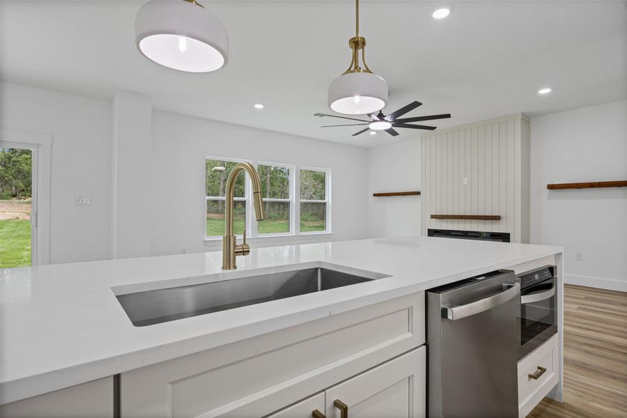 Kitchen island with a built-in stainless steel sink and a gold-finish faucet Kitchen island with a built-in stainless steel sink and a gold-finish faucet