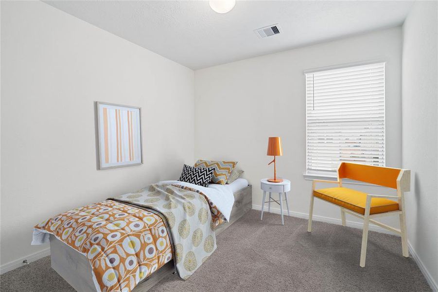 Secondary bedroom features plush carpet, custom paint, lighting, ample closet space, and a large window with privacy blinds.